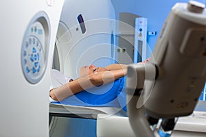 Pretty, young woman goiing through a Computerized Axial Tomography CAT Scan medical test/examination in a modern hospital color
