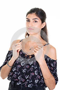 Pretty young woman hair tied with hands on the straps of her top portrait with dark hair brown on white background