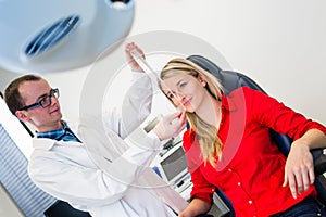 Pretty young woman having her eyes examined