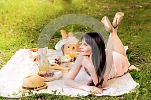 The pretty young woman having picnic on sunny day