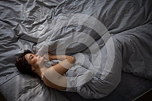 Pretty, young woman in her bed, fast asleep.