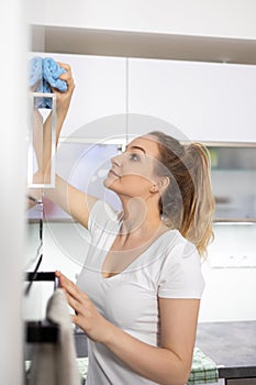 Pretty, young woman in her modern,  bright kitchen