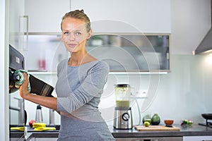 Pretty, young woman in her modern kitchen