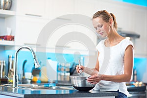 Pretty, young woman in her modern kitchen