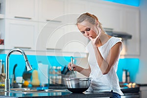 Pretty, young woman in her modern kitchen
