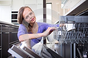 Pretty, young woman in her modern and well equiped kitchen photo