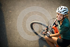 Pretty, young woman with her mountain bike going for a ride past the city limits