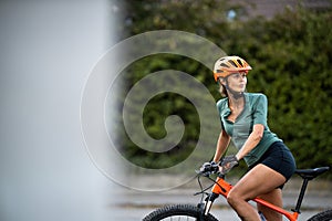 Pretty, young woman with her mountain bike going for a ride past the city limits