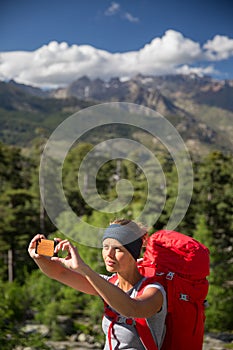 Pretty, young woman hiker taking a selfie photo