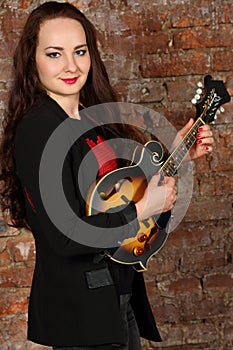 Pretty young woman hold mini guitar in studio with