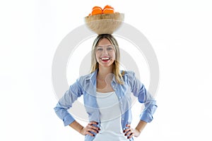 Pretty young woman holding a bowl over her head with oranges over white background