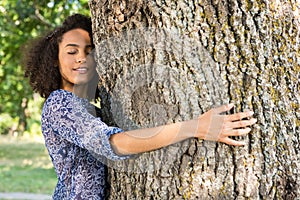 Pretty young woman hugging a tree