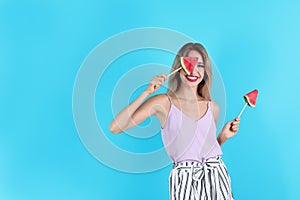 Pretty young woman with juicy watermelon on color background