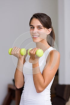 Pretty young woman lifting dumbbells