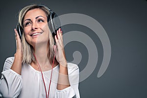 Pretty, young woman listening to her favorite music on hi-fi headphone