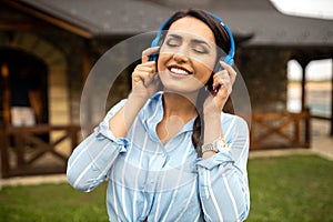 Pretty young woman listening to music with closed eyes