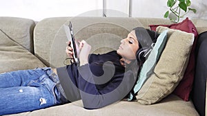 Pretty young woman listening to music with headphones