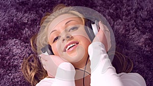 Pretty young woman listening to music on headphones