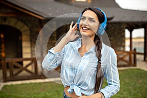 Pretty young woman listening to music outdoors