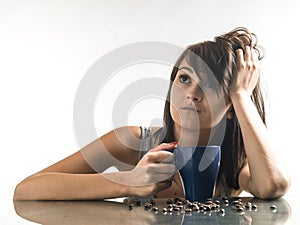 Pretty, young woman looking coffee mugs on bright background