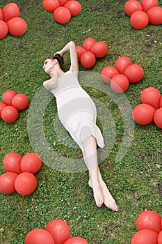 Pretty young woman lying down on grass. Fashion model