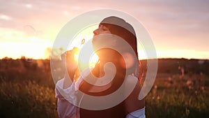 pretty young woman making soap bubbles in summer green field on sunset. happy peaceful time. millennial generation