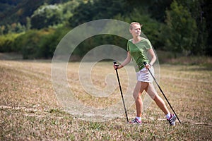 Pretty, young woman nordic walking