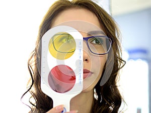 Pretty young woman optometrist ophthalmologist optician performs a color blindness test