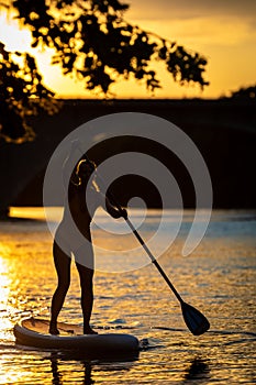 Pretty, young woman paddle boarding