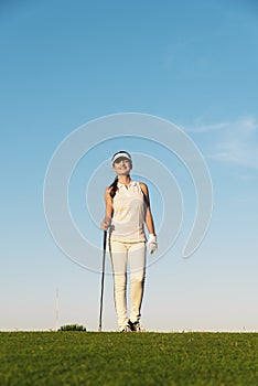 Pretty young woman playing golf.