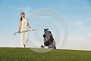 Pretty young woman playing golf.