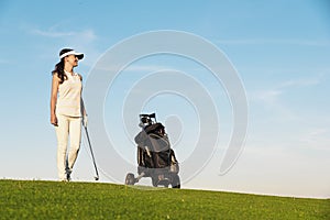 Pretty young woman playing golf.