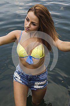 Pretty young woman portrait outdoors, wearing jeans shorts