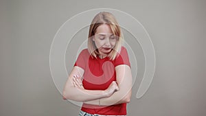Pretty young woman posing isolated on grey wall sceptic shocked view