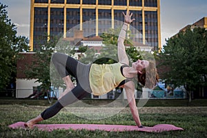 Pretty Young Woman Practicing Yoga in the Park (Side Plank)