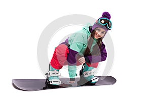 Pretty young woman in purple ski suit rides black snowboard