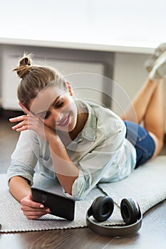 Pretty young woman reading an e-book