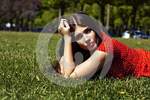 pretty young woman in red dress smiling cheerful in green park on summer sunny day, lifestyle people concept