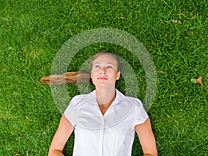 Pretty young woman relaxing on a grass