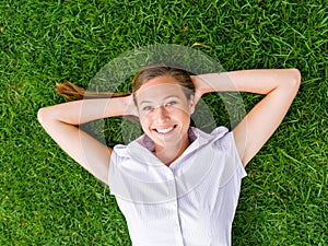 Pretty young woman relaxing on a grass