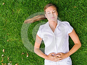 Pretty young woman relaxing on a grass