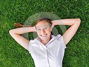 Pretty young woman relaxing on a grass