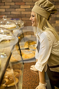 Pretty young woman selling fresh products in the bakery