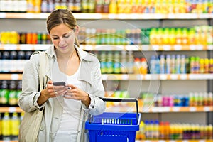 Pretty, young woman with a shopping basket buying groceries