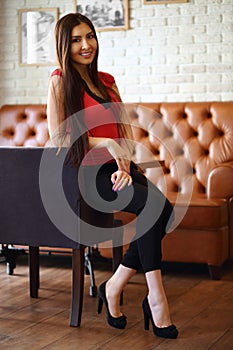 Pretty young woman sits at seat in empty cozy cafe