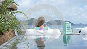 Pretty young woman sitting in lounger using digital tablet during vacation.