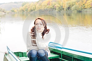 Pretty young woman sitting in a rowboat