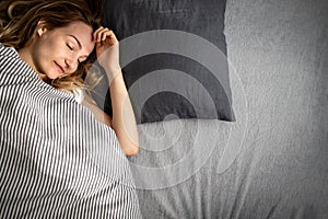 Pretty, young woman sleeping in her bed late in the morning