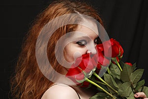 Pretty young woman smelling roses