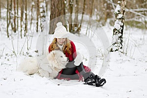 Pretty Young Woman in Winter Forest Walking with her Dog White Samoyed